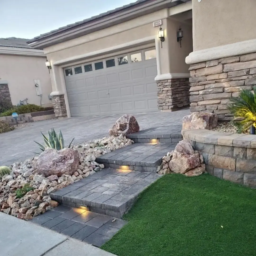 Modern house with stone pathway and lights.