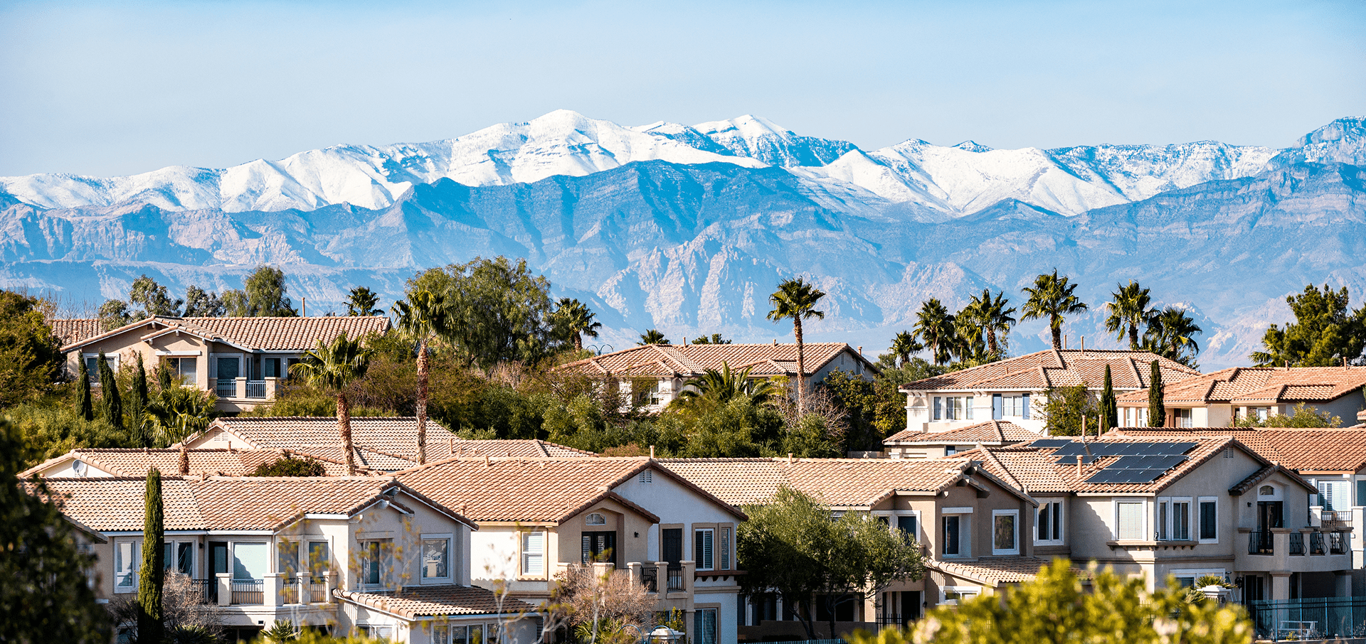 Suburban homes with snowy mountain backdrop.