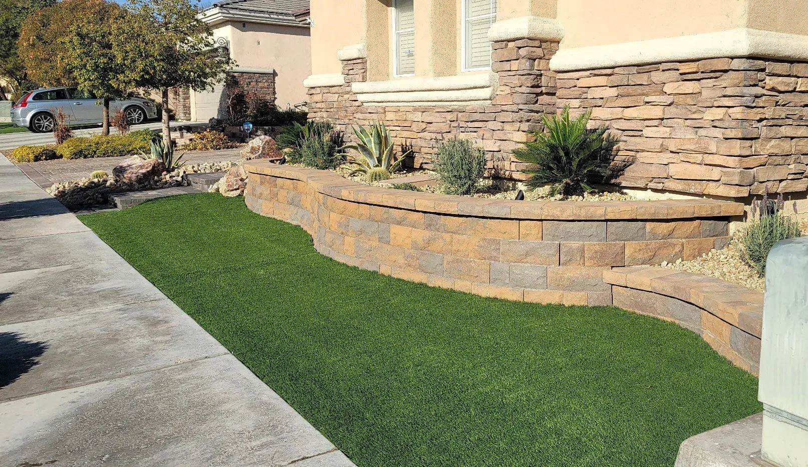 House with landscaped front yard and artificial grass.